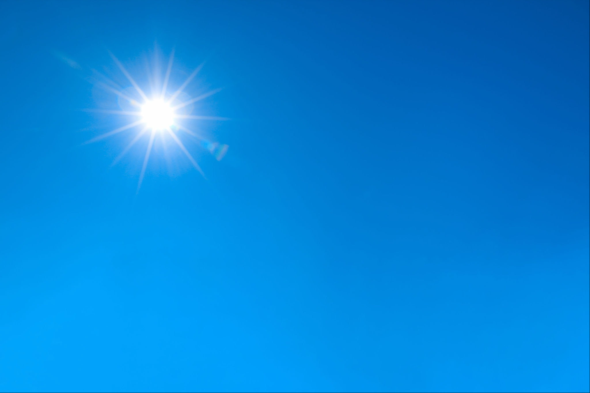 bright sun shines on clear blue sky.